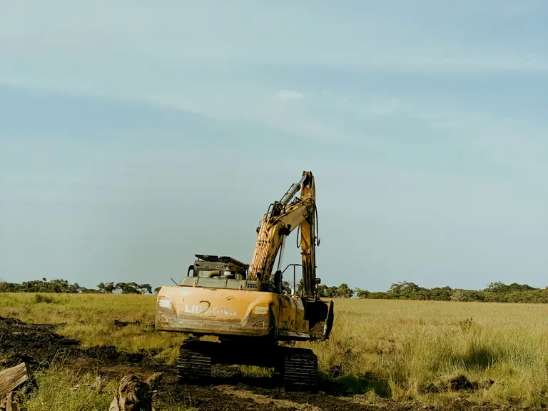 Excavator working open ground being cleared and prepared for construction